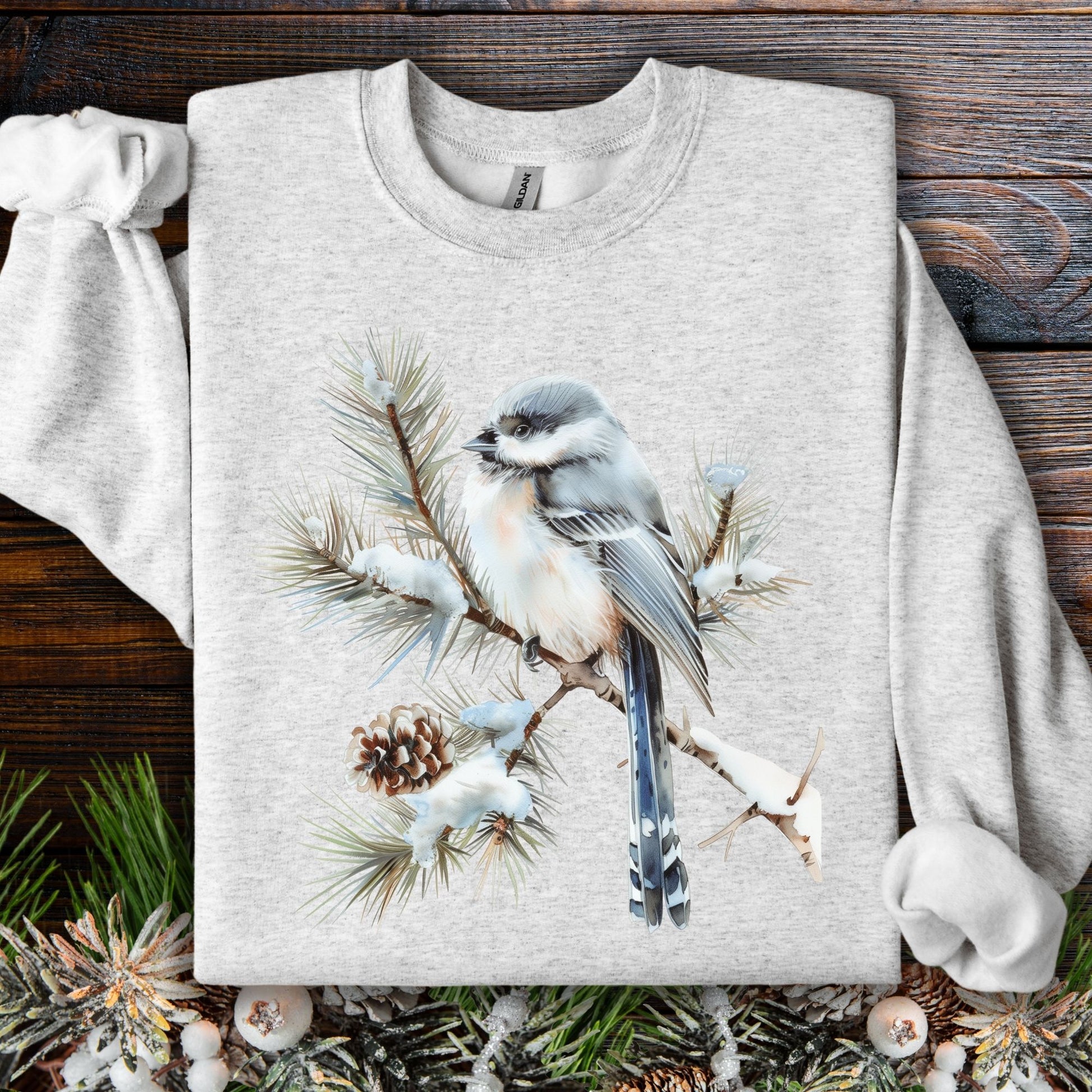 Light gray Gildan 18000 sweatshirt with a watercolor long-tailed tit on a snowy evergreen branch.
