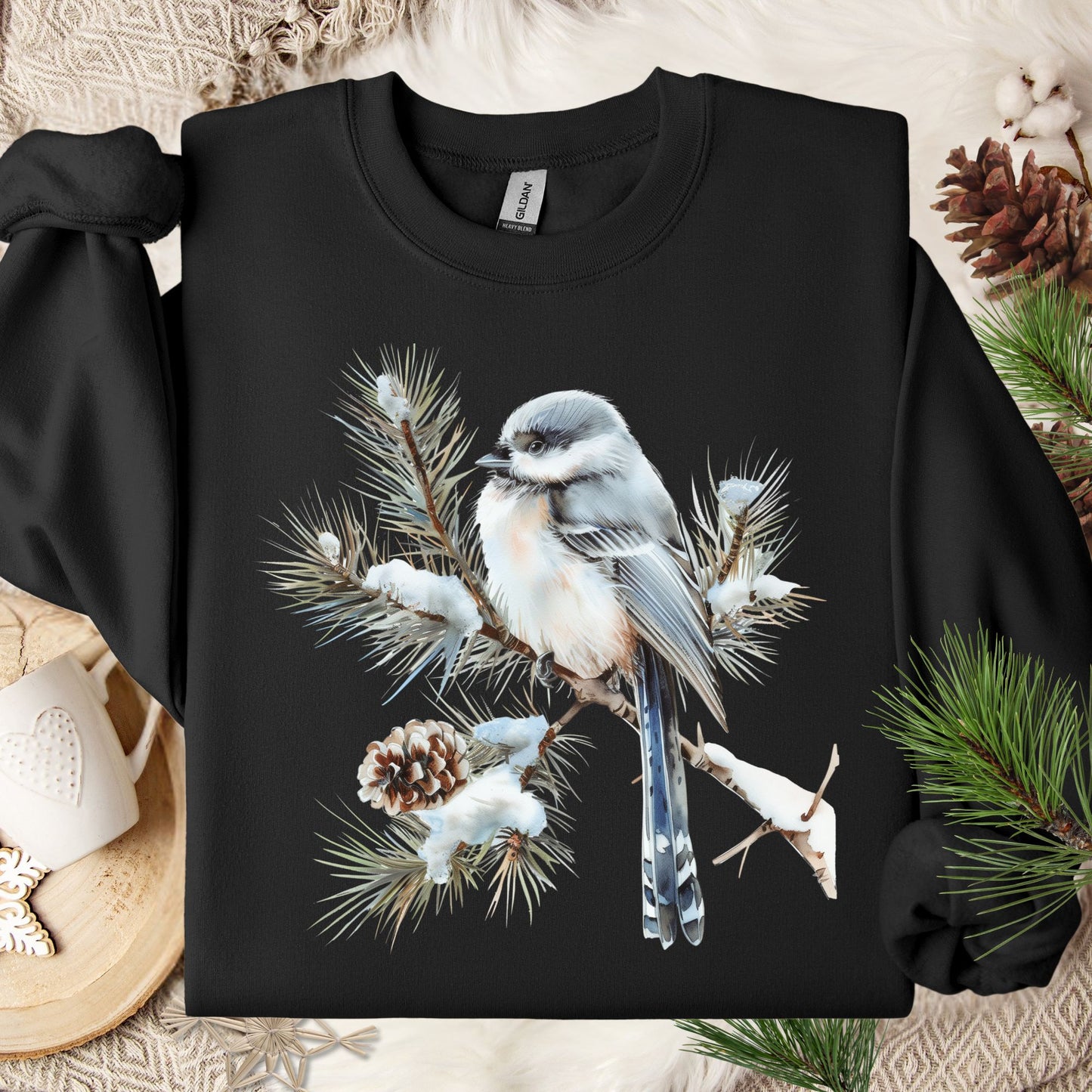 Black Gildan sweatshirt with a watercolor long-tailed tit on a snow-tipped evergreen branch.