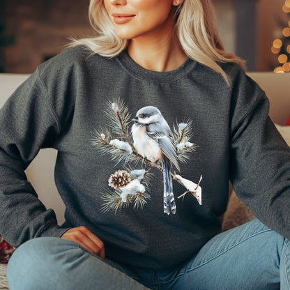 Charcoal gray sweatshirt with a watercolor long-tailed tit on a snowy evergreen branch, worn by a blonde woman.