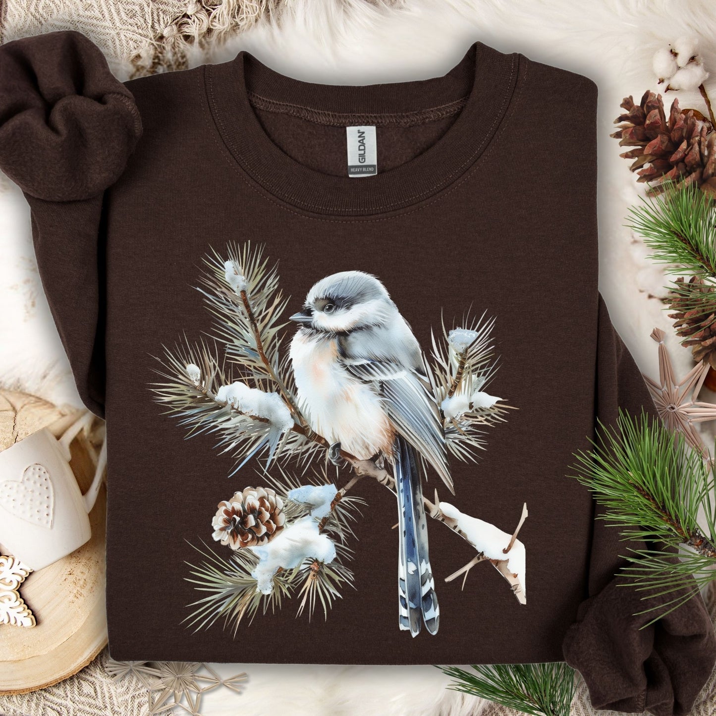 Dark Chocolate Gildan S sweatshirt with a watercolor long-tailed tit on a snowy evergreen bough.