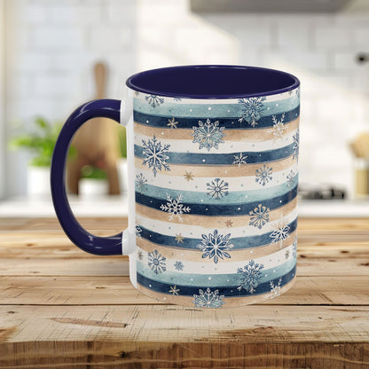 Ceramic mug with blue and beige watercolor stripes, white snowflakes, and a dark blue interior and handle.