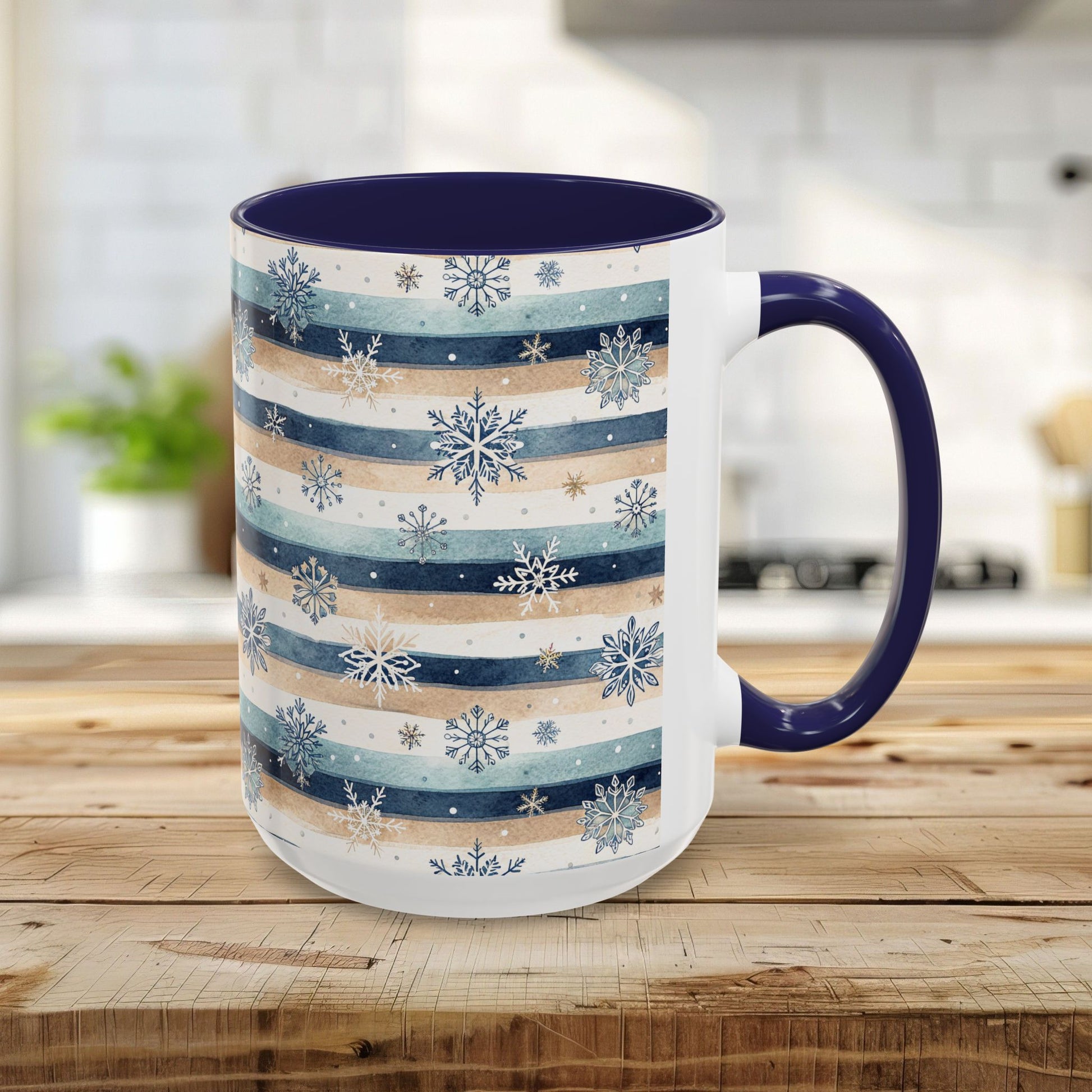 White ceramic mug with blue and beige watercolor stripes, delicate snowflakes, and a contrasting navy interior and handle.