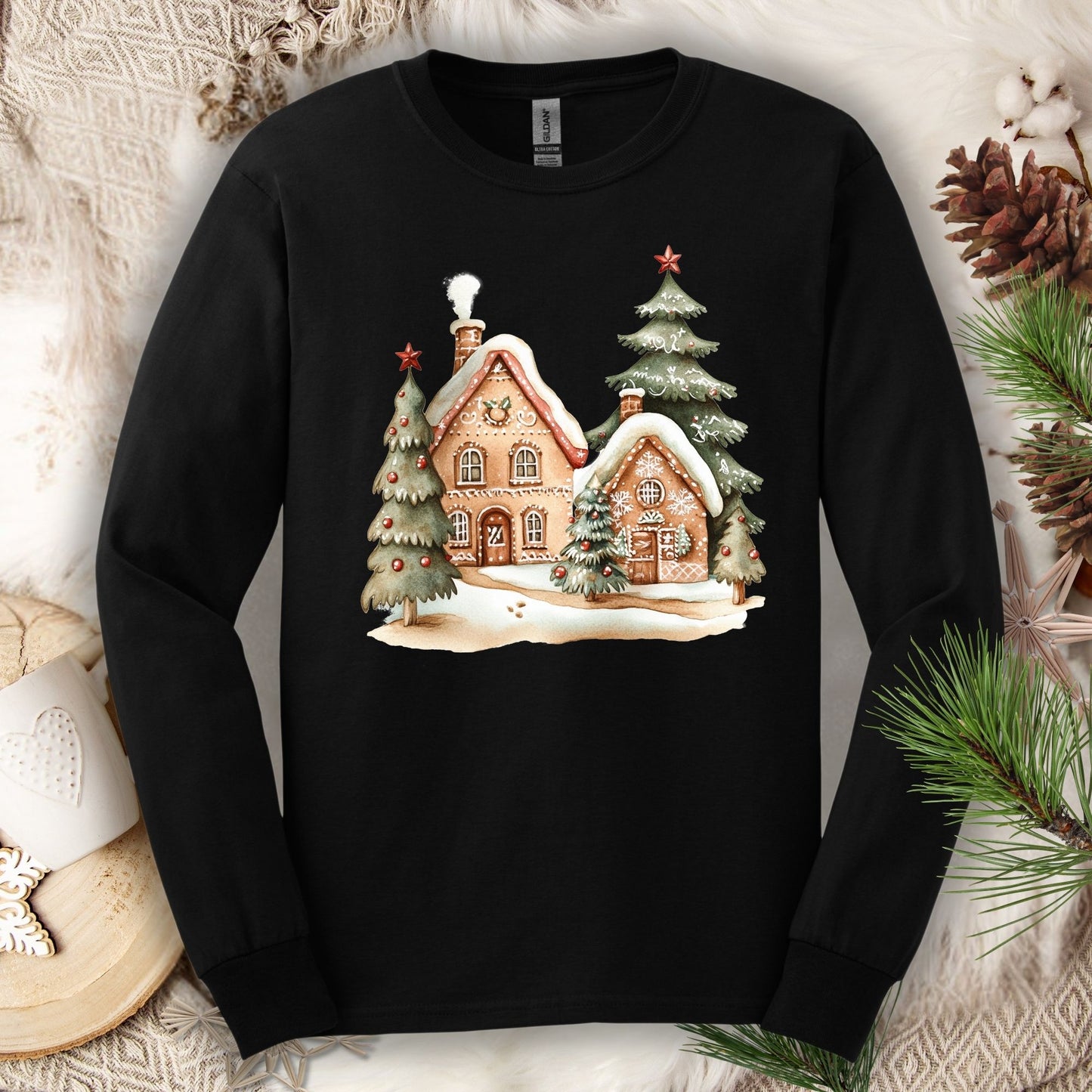 Black Gildan long sleeve tee with a watercolor gingerbread house and evergreen tree design.