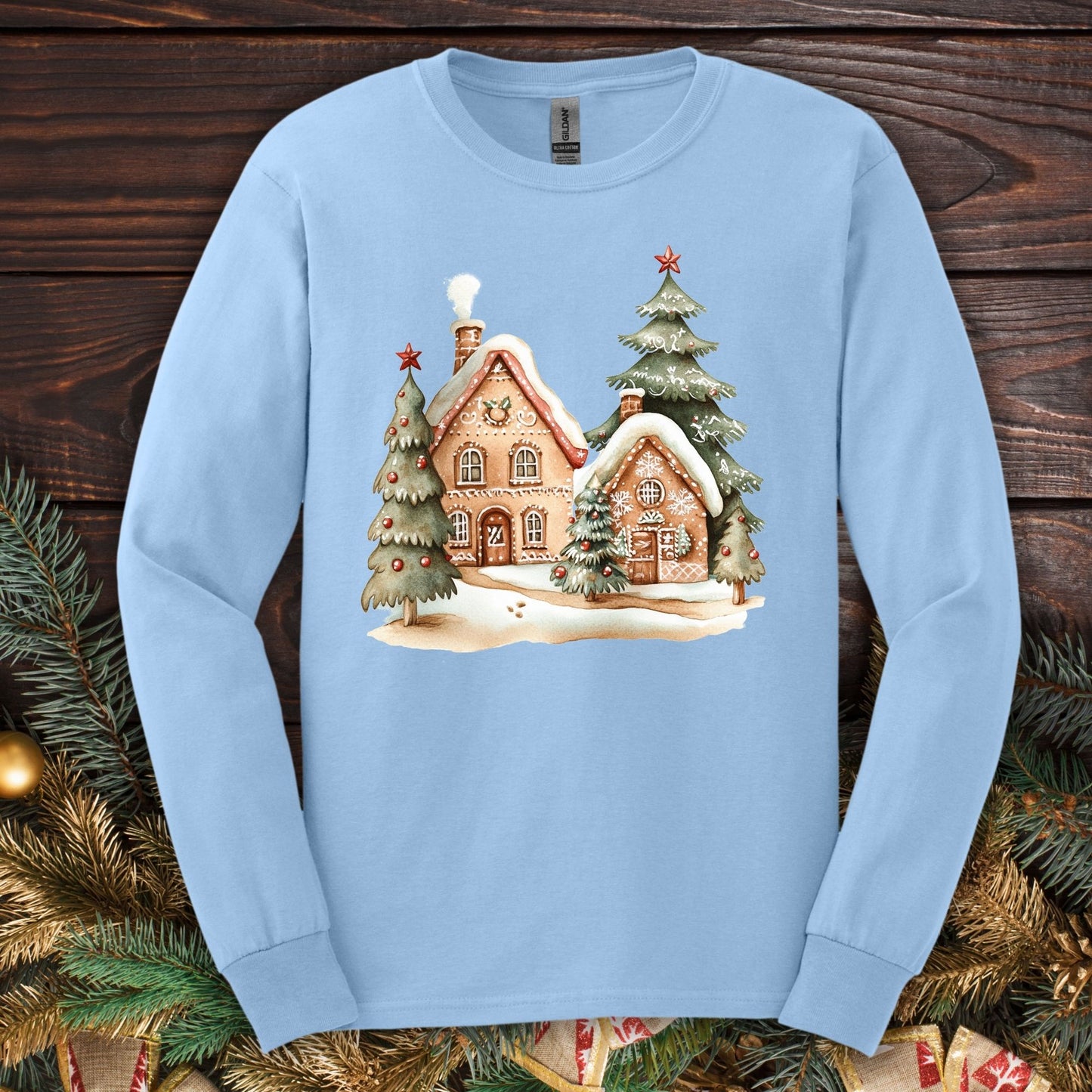 Light blue Gildan long sleeve tee with a watercolor gingerbread house winter wonderland design.
