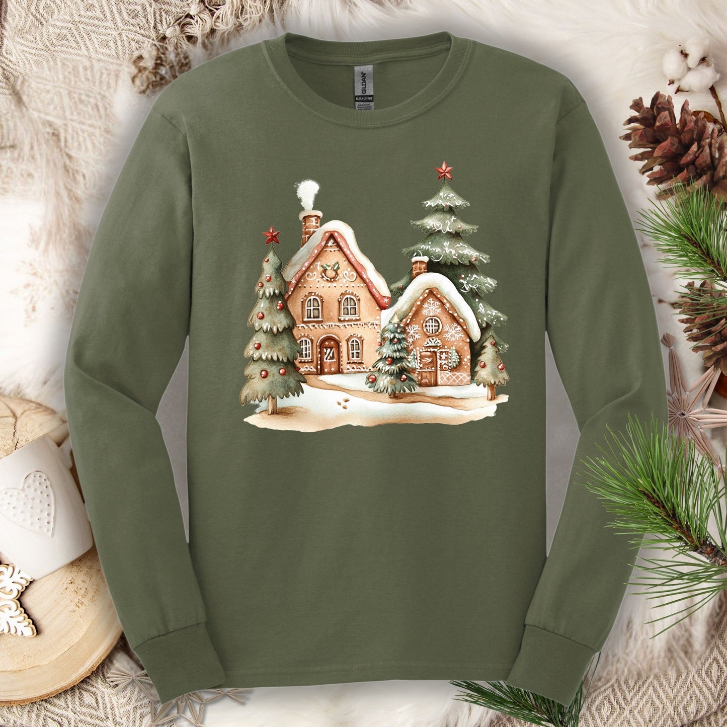 Military Green Gildan 2400 long sleeve tee with watercolor gingerbread houses and snowy evergreens.