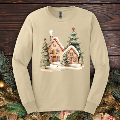 Sand Gildan 2400 long sleeve tee with watercolor gingerbread homes, evergreens, and snow design.
