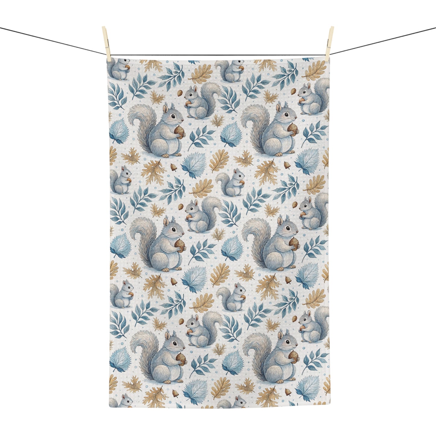 Microfiber tea towel with watercolor squirrels and autumn leaves, hanging on a clothesline.
