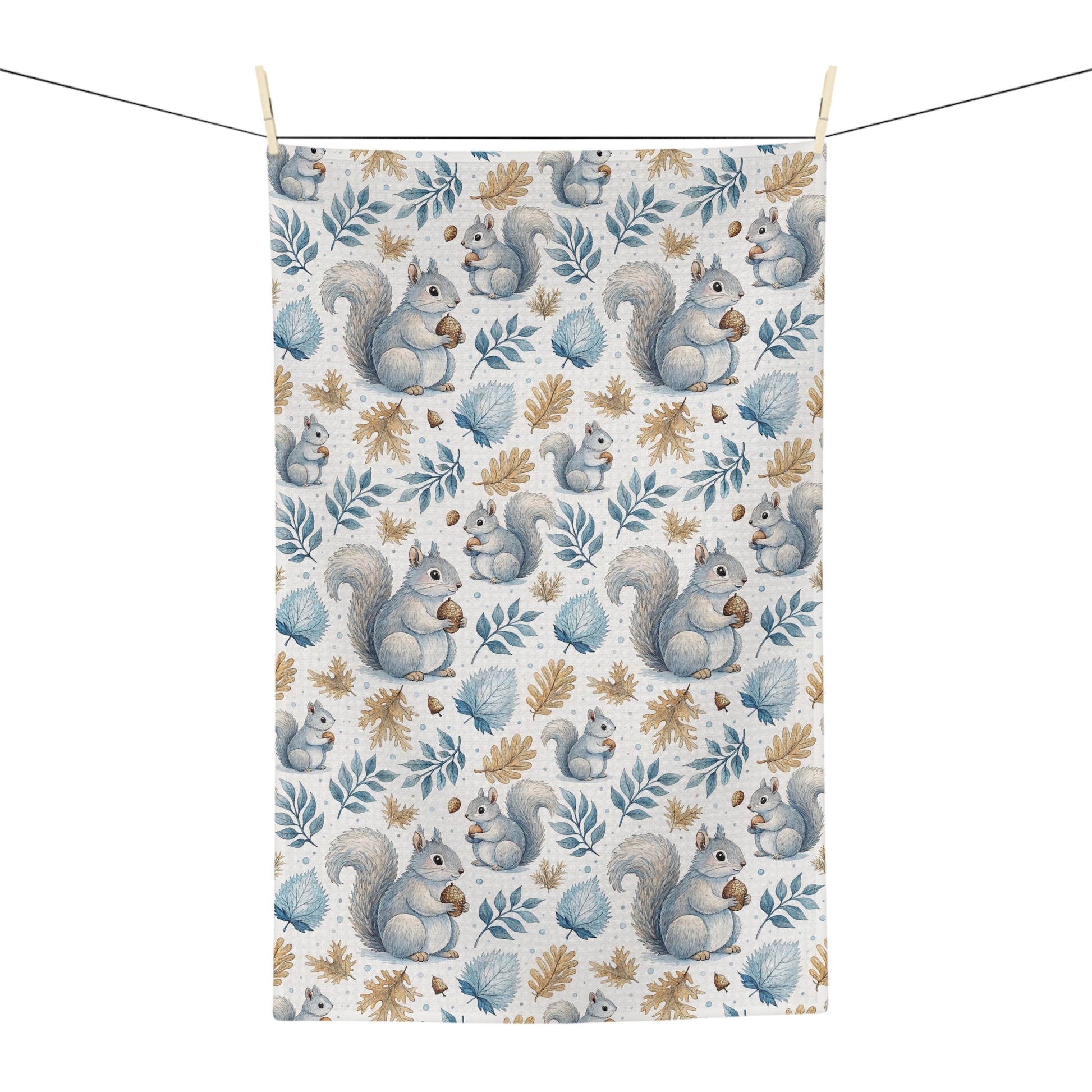 Microfiber tea towel with watercolor squirrels and autumn leaves, hanging on a clothesline.