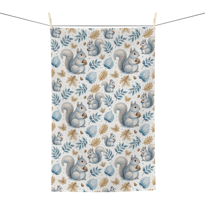 Microfiber tea towel with watercolor squirrels and autumn leaves, hanging on a clothesline.