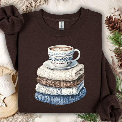Dark Chocolate S sweatshirt with a watercolor-style print of stacked knit sweaters and a patterned coffee mug.
