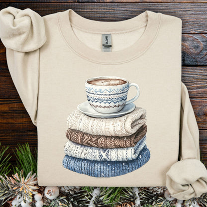 Sand S cotton-poly sweatshirt with a watercolor stack of knit sweaters and a patterned coffee mug.