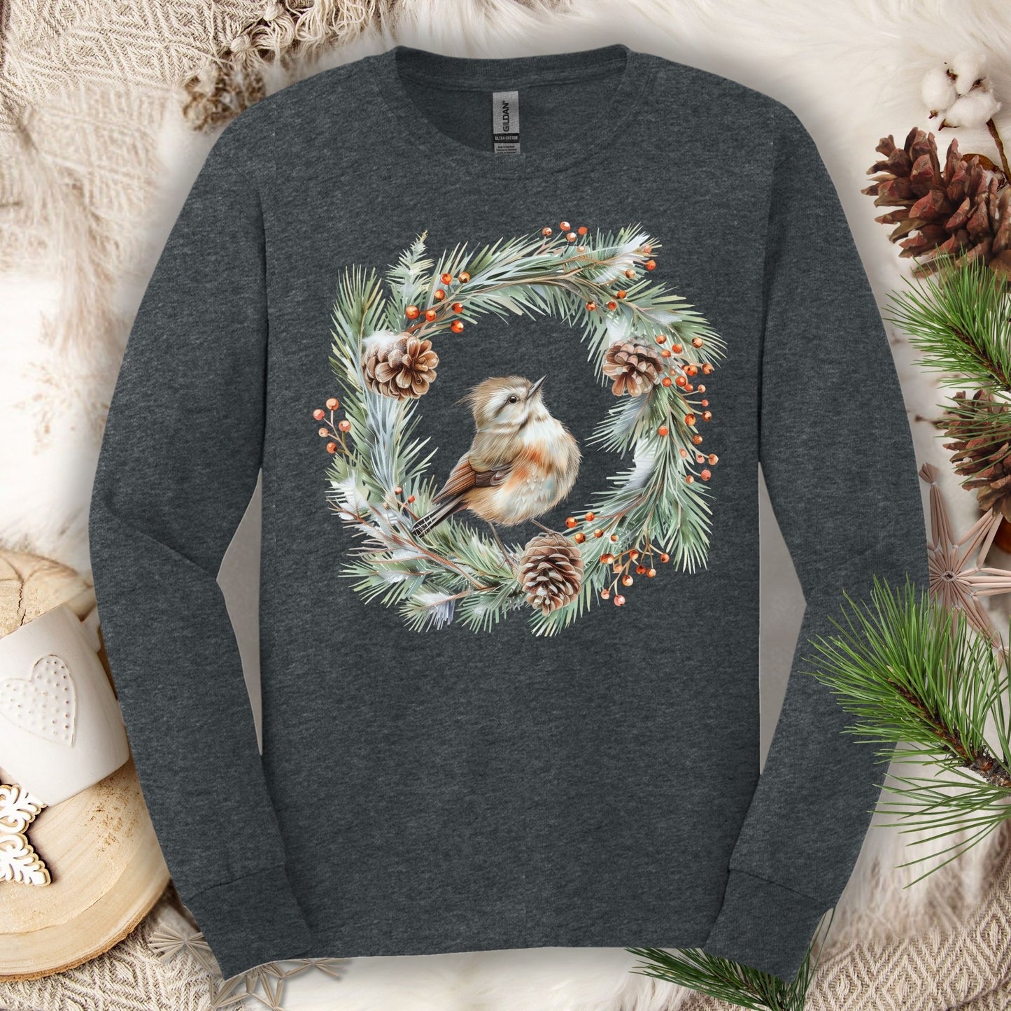 Dark Heather long sleeve tee with a watercolor winter wren in an evergreen wreath with pinecones and berries.