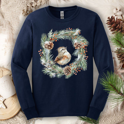 Navy long sleeve tee with a watercolor winter wren in an evergreen and pinecone wreath.