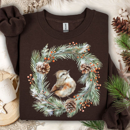 Dark brown sweatshirt with watercolor wren in evergreen wreath, pinecones, and red berries.