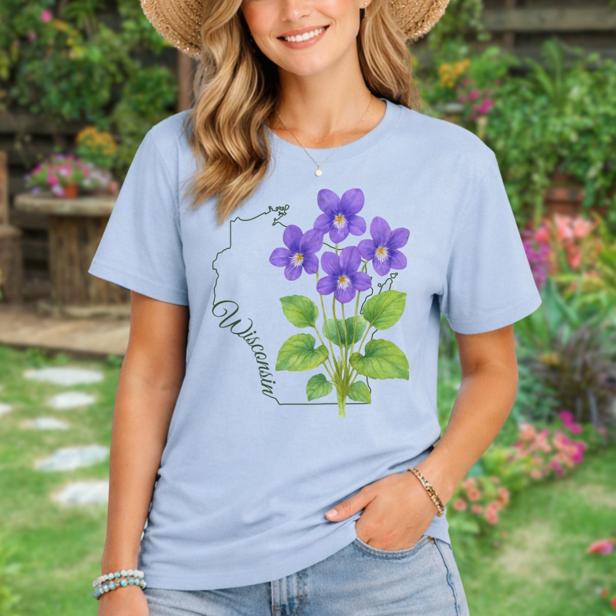 Garment-dyed light blue t-shirt with a watercolor wood violet cluster and Wisconsin state outline.