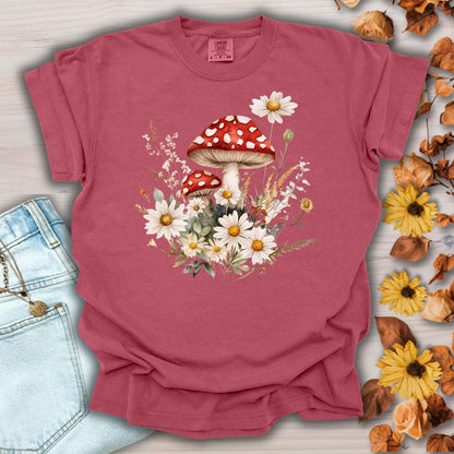 Crimson garment-dyed t-shirt with a vintage floral mushroom graphic, shown with jeans and autumn leaves.