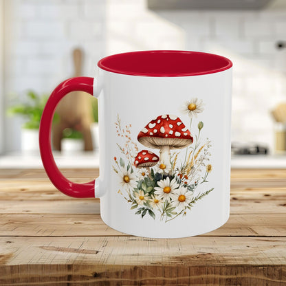 White ceramic mug with red interior and handle, featuring a watercolor print of red-capped mushrooms and daisies.