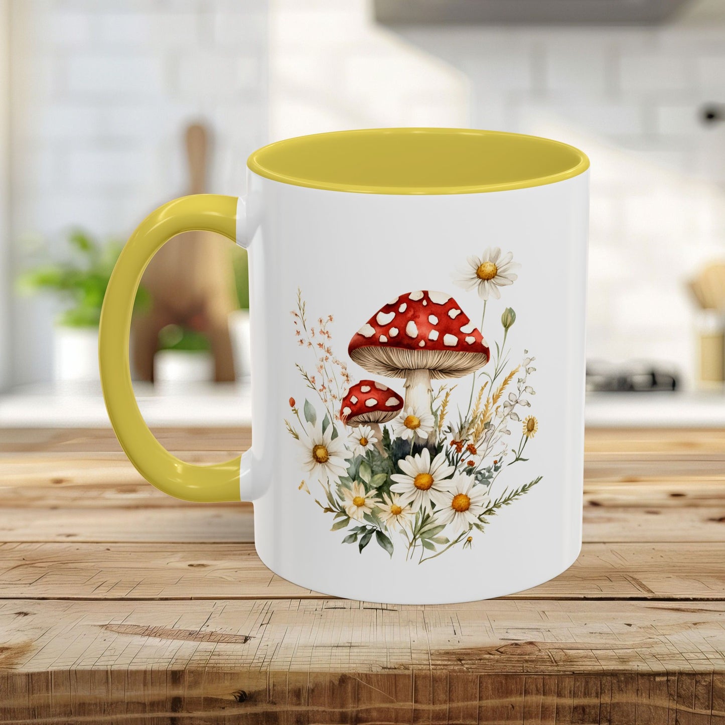 White ceramic mug with yellow interior and handle, featuring a watercolor print of red-capped mushrooms and daisies.