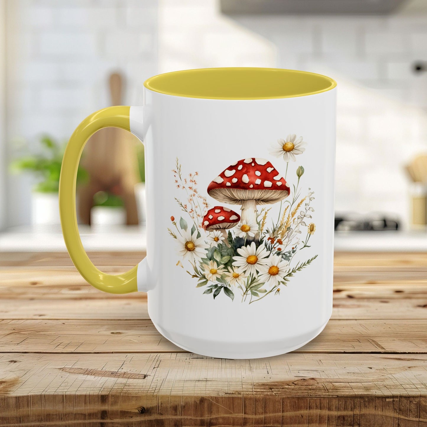 White ceramic mug with yellow handle and interior, featuring a watercolor print of red-capped mushrooms and white daisies.