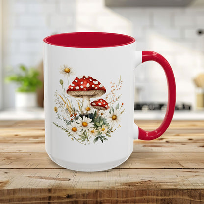 15oz ceramic mug with red interior/handle, featuring a watercolor print of red-capped mushrooms, daisies, and grasses.