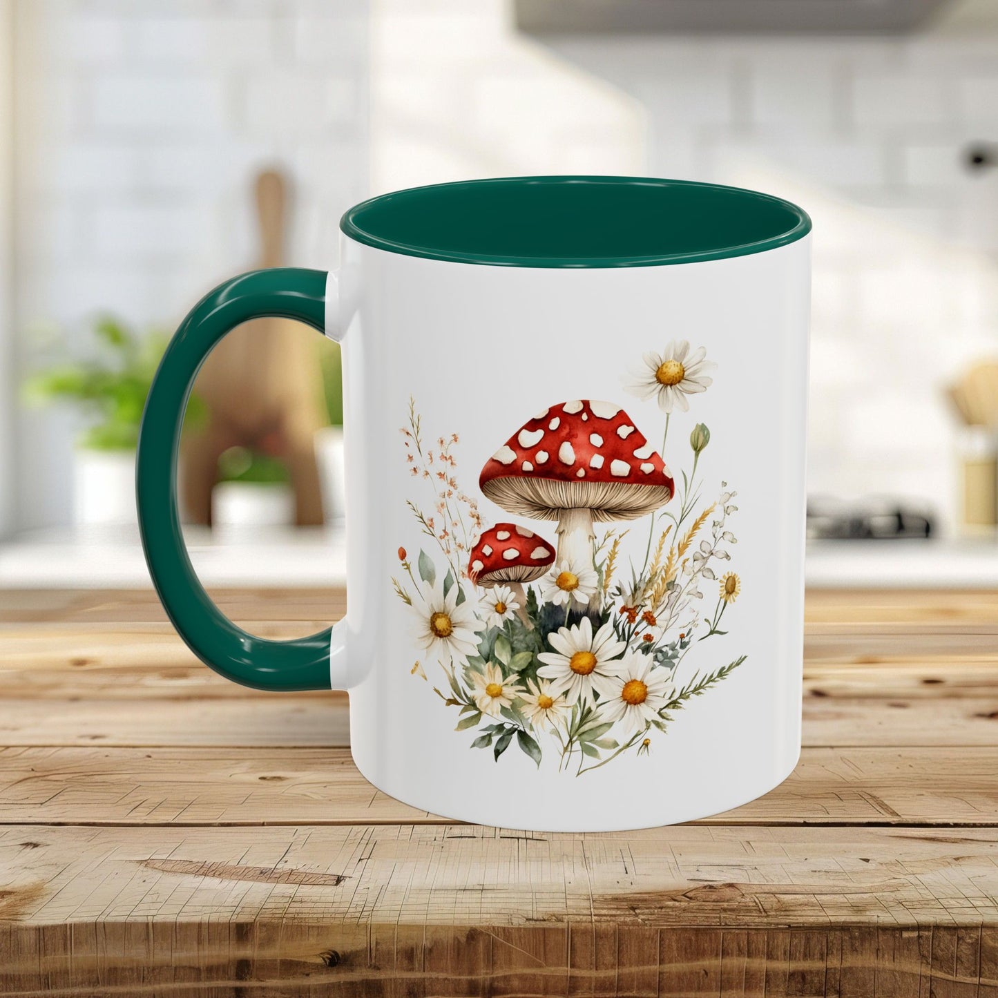 White ceramic mug with green handle and interior, featuring a watercolor print of red-capped mushrooms and daisies.