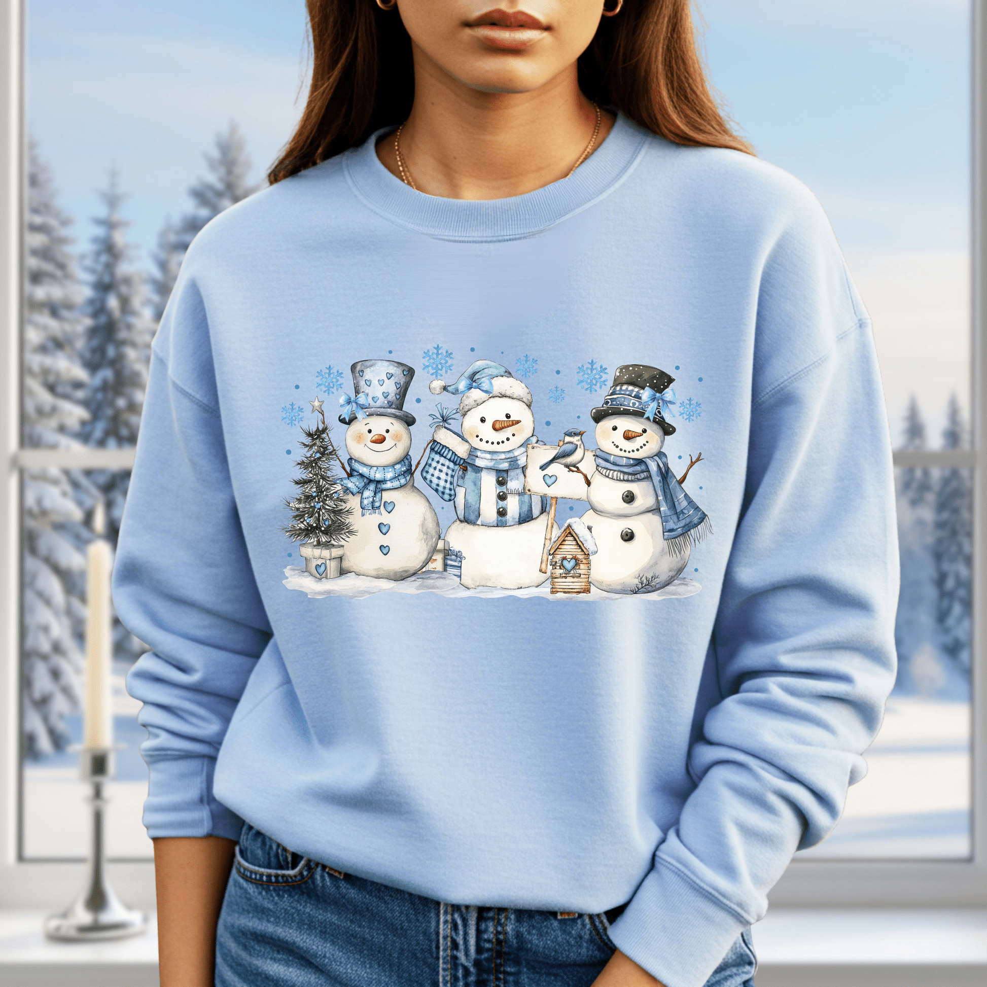 Light blue cotton-polyester sweatshirt with watercolor snowmen, blue hats, scarves, birdhouse, and winter scene.