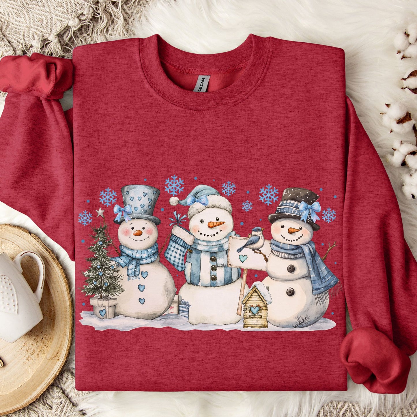 Antique Cherry Red sweatshirt with three watercolor snowmen, blue hats/scarves, birdhouse, and snowflakes.
