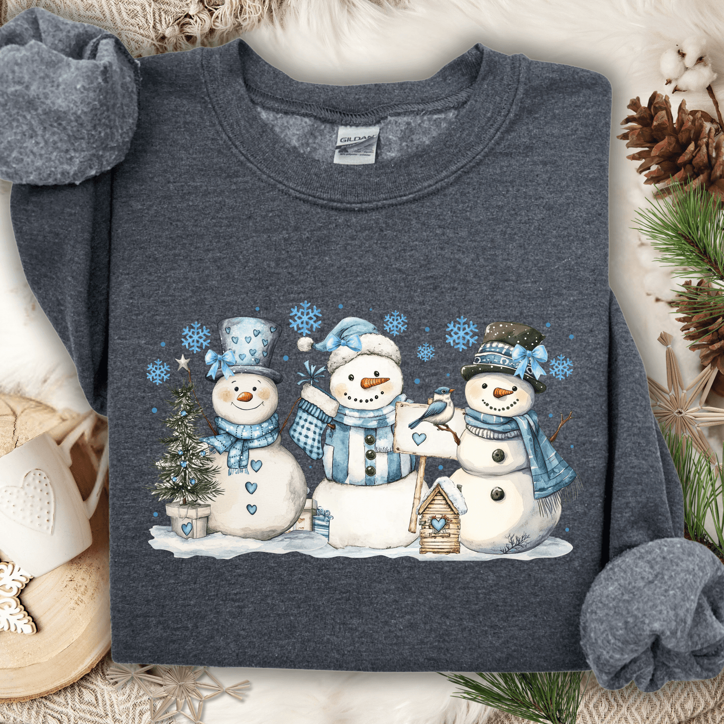 Dark Heather sweatshirt with watercolor snowmen, blue hats/scarves, birdhouse, and snowflakes.