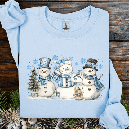 Light blue cotton-polyester sweatshirt with three watercolor snowmen, blue hats, scarves, birdhouse, and birds.