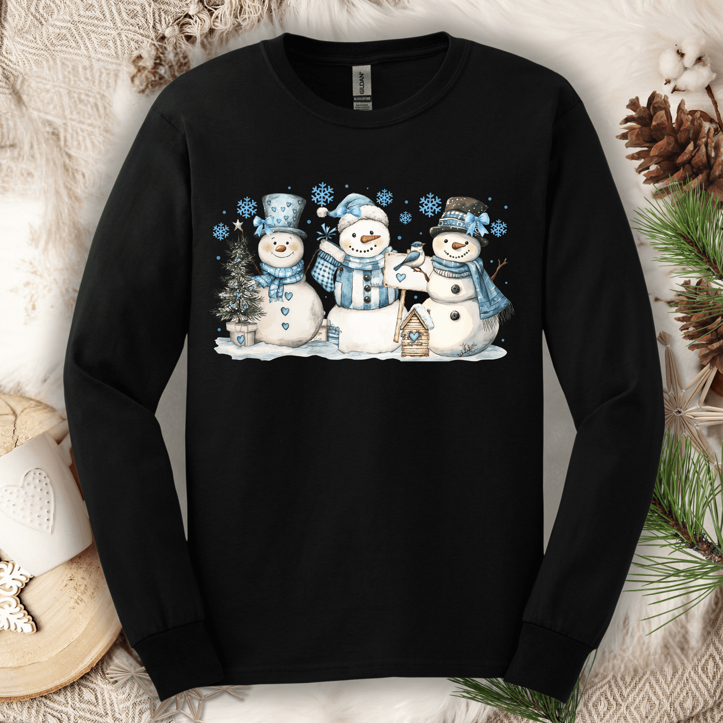 Black long-sleeve tee with three watercolor snowmen, blue hats, scarves, and snowflakes.