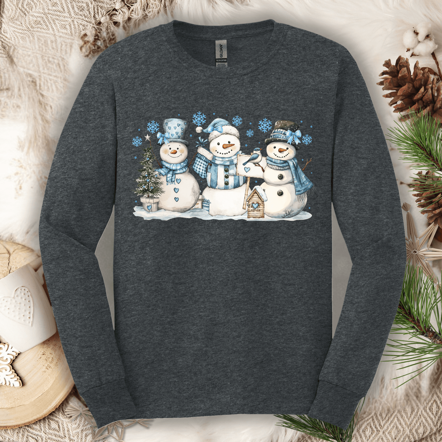 Dark Heather long sleeve tee with three watercolor snowmen in blue hats and scarves.