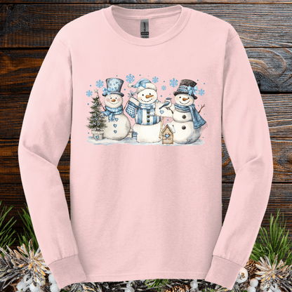 Light pink long sleeve tee with watercolor snowmen, blue hats, scarves, and snowflakes.
