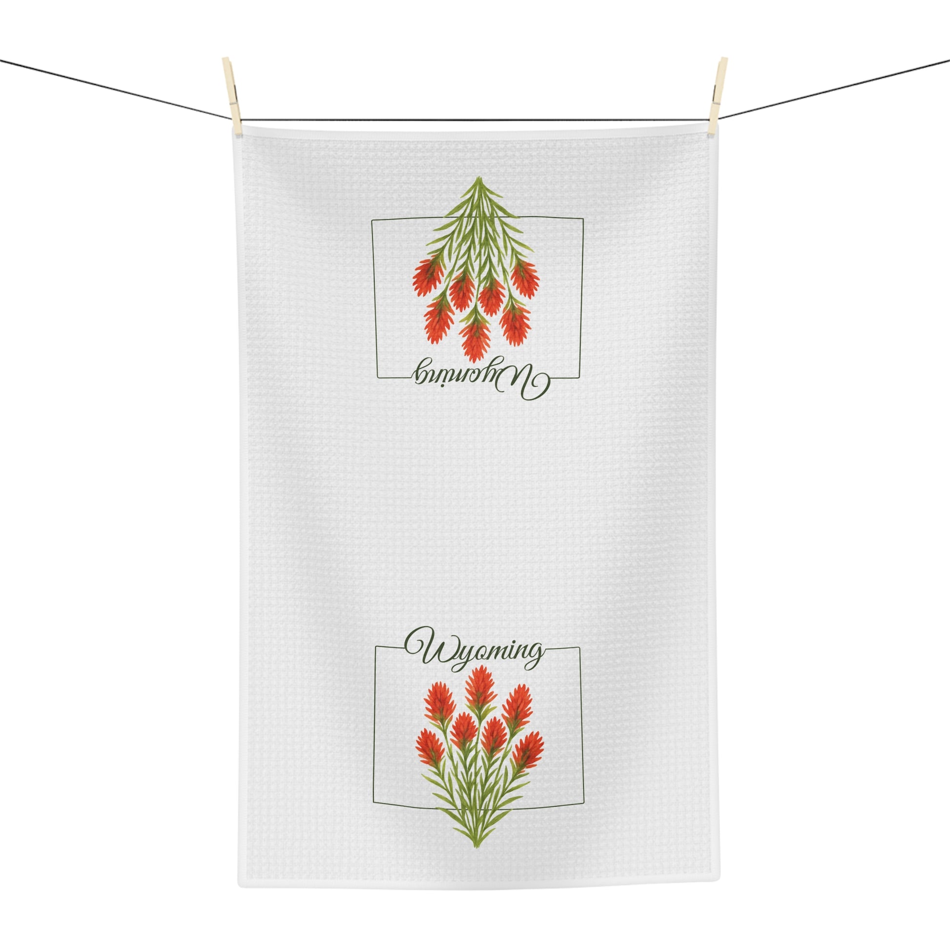 White microfiber tea towel with two red Indian Paintbrush flower designs and "Wyoming" script.