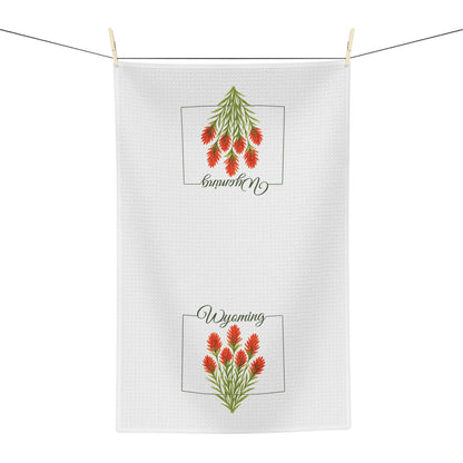 White microfiber tea towel with two red Indian Paintbrush flower designs and "Wyoming" script.