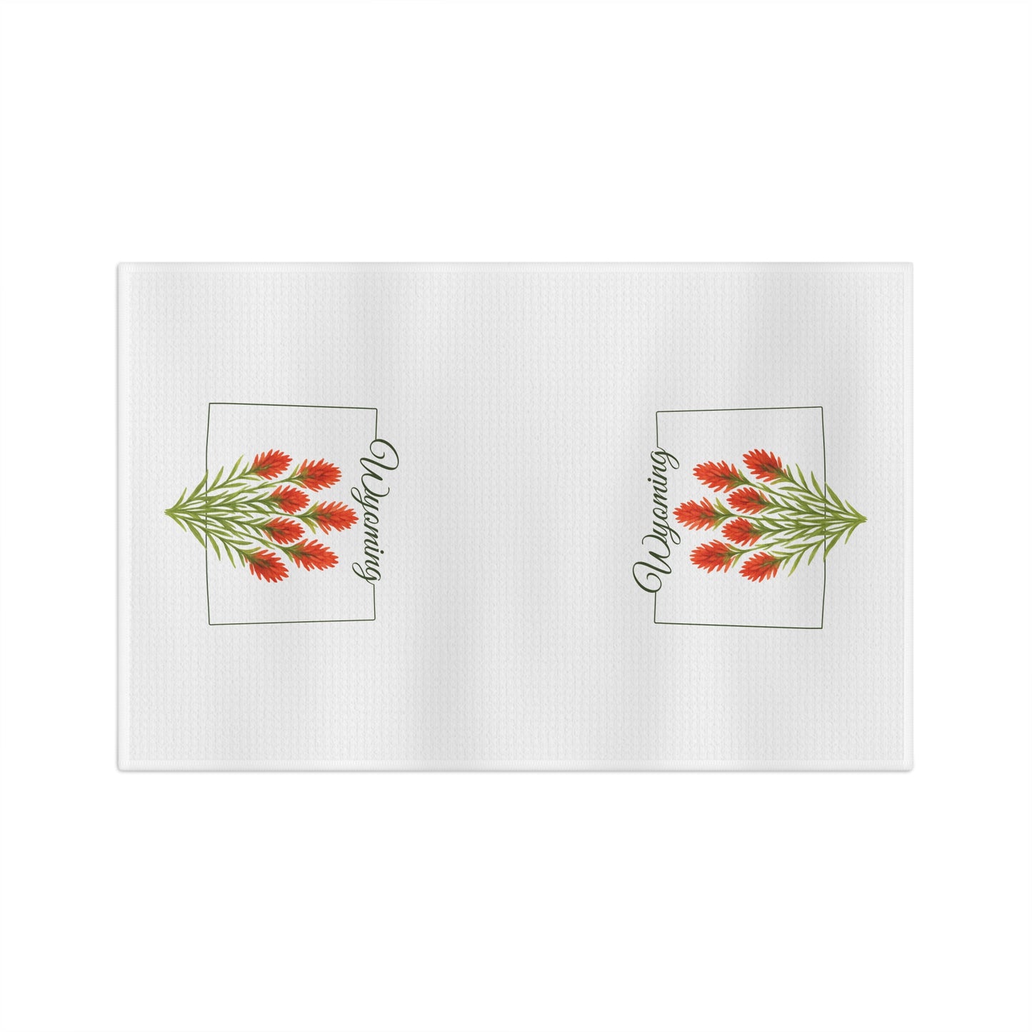 White microfiber tea towel with two red Indian paintbrush sprigs and "Wyoming" in a square frame.
