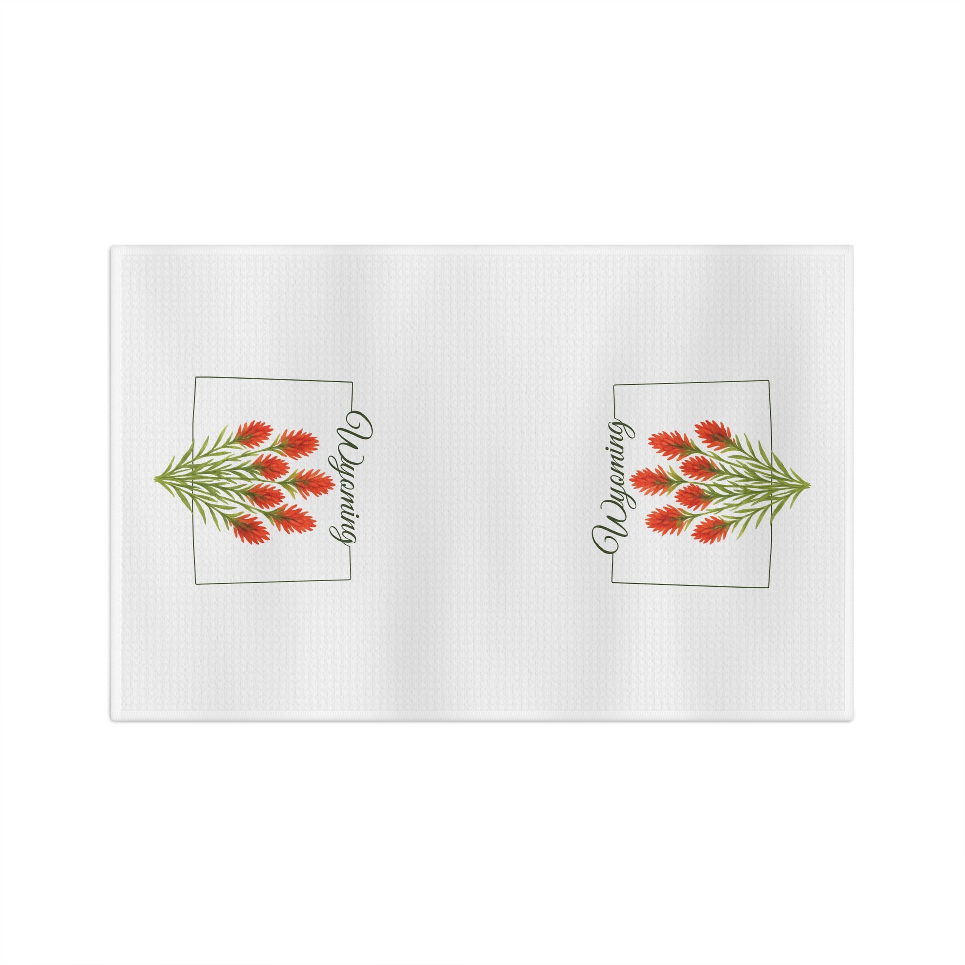 White microfiber tea towel with two red Indian paintbrush sprigs and "Wyoming" in a square frame.