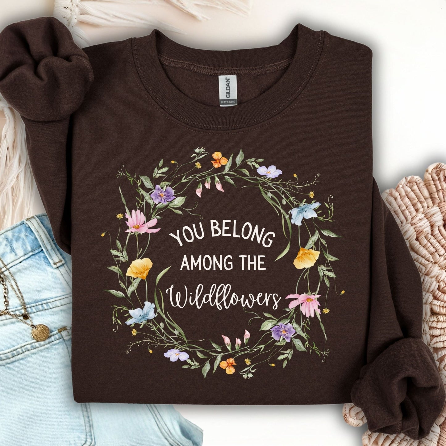 Dark chocolate Gildan sweatshirt with a watercolor wildflower wreath and "You belong among the wildflowers" text.