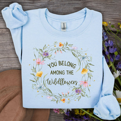 Light blue Gildan sweatshirt with "You belong among the wildflowers" in a watercolor floral wreath.