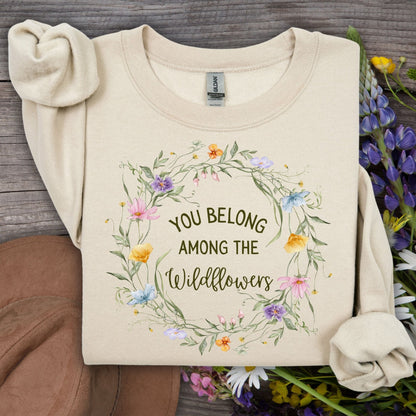 Sand Gildan crewneck sweatshirt with "You belong among the wildflowers" in a watercolor floral wreath.