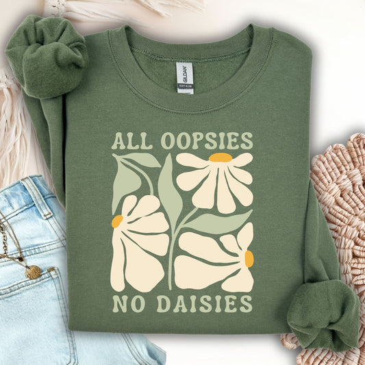 Green sweatshirt with floral design and text 'All oopsies no daisies' on a light background